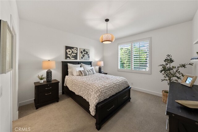 bedroom featuring light colored carpet and baseboards