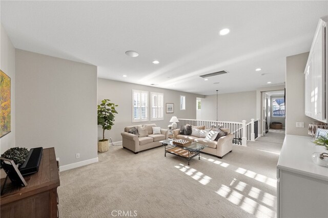 living area with baseboards, light carpet, and recessed lighting