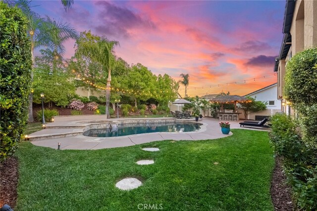 outdoor pool featuring a lawn and a patio area