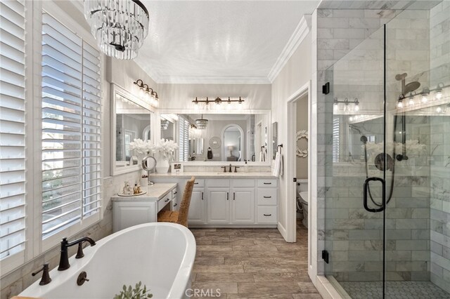 full bathroom with crown molding, wood finished floors, a freestanding bath, a chandelier, and a shower stall