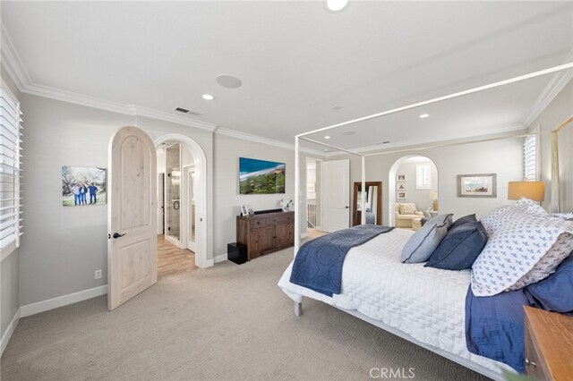 bedroom featuring visible vents, arched walkways, crown molding, and light carpet