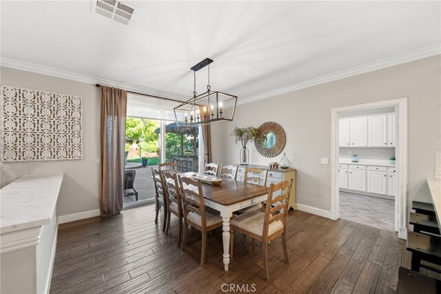 dining area featuring an inviting chandelier, ornamental molding, baseboards, and visible vents