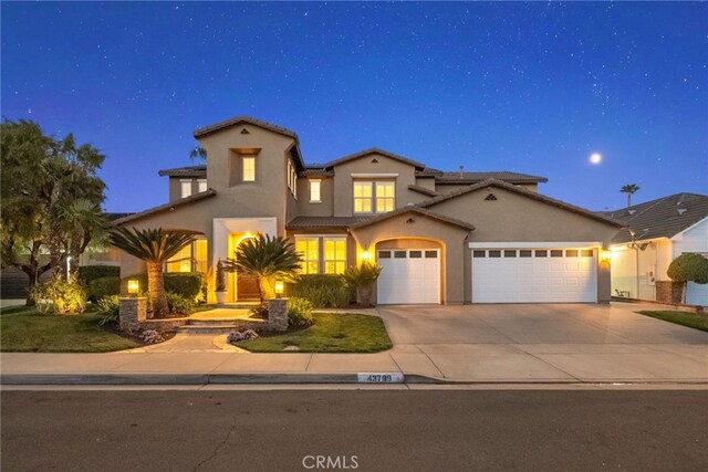 mediterranean / spanish-style house featuring a garage, stucco siding, driveway, and a tiled roof