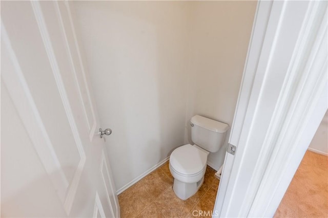 bathroom featuring tile patterned flooring, toilet, and baseboards