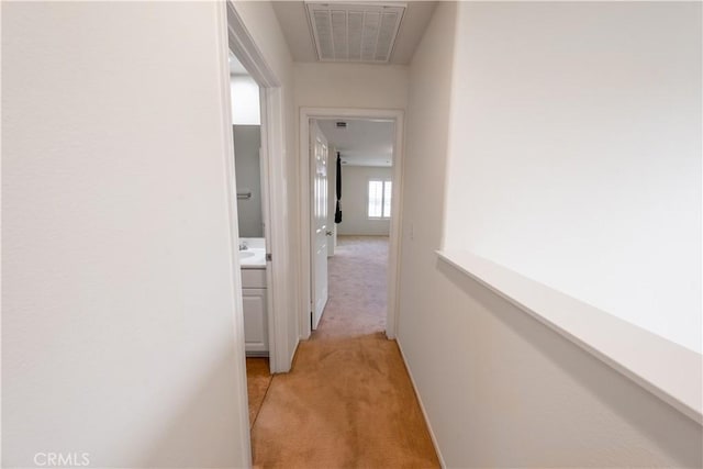 hall featuring visible vents and light colored carpet