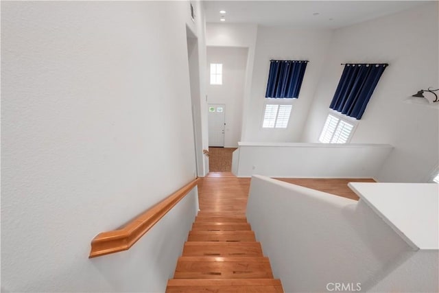 stairway featuring wood finished floors and recessed lighting