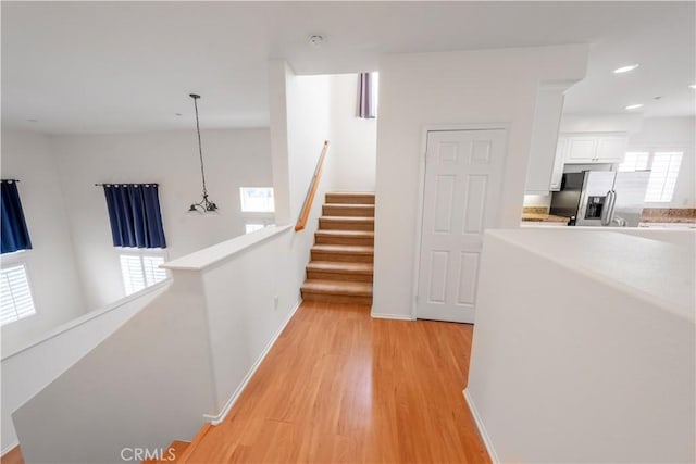 hallway with recessed lighting, light wood-type flooring, baseboards, and stairway