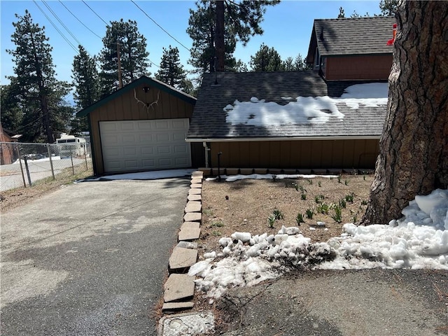 31671 Silver Spruce Dr, Running Springs, CA 92382 - view of home's exterior featuring driveway, board and batten siding, fence, a garage, and roof with shingles