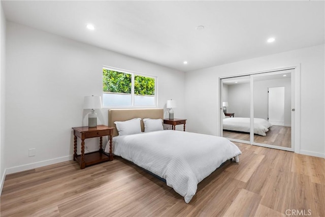 bedroom featuring light wood-style flooring, recessed lighting, baseboards, and a closet