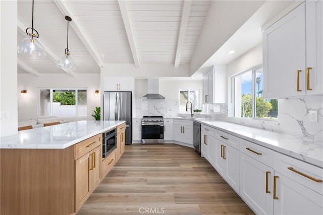kitchen with stainless steel appliances, wall chimney range hood, plenty of natural light, light wood finished floors, and recessed lighting