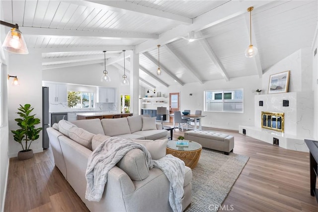 living area featuring light wood finished floors, baseboards, a fireplace, and wooden ceiling