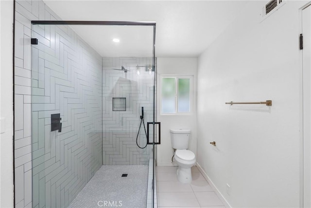 full bathroom featuring toilet, a shower stall, tile patterned floors, and baseboards