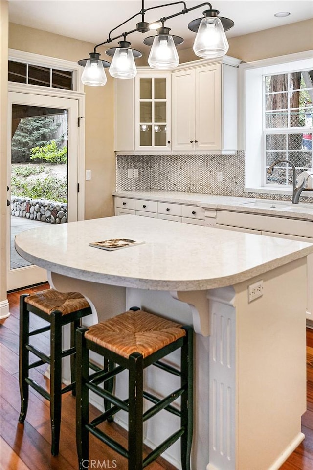 kitchen with white cabinetry, a sink, a wealth of natural light, and a kitchen island