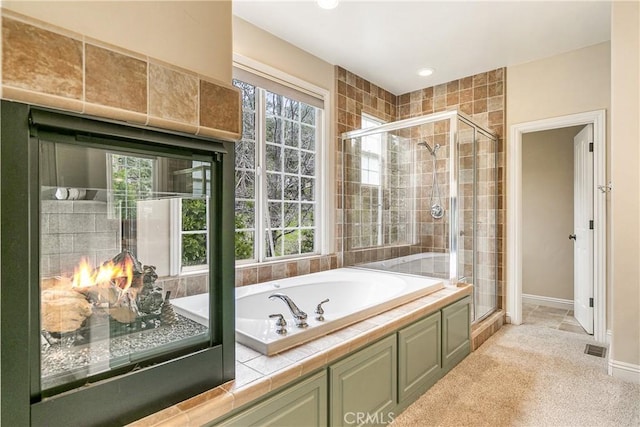 full bathroom with visible vents, a bath, a shower stall, and baseboards