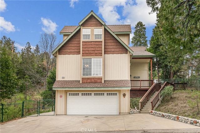 view of front facade featuring an attached garage, concrete driveway, and fence