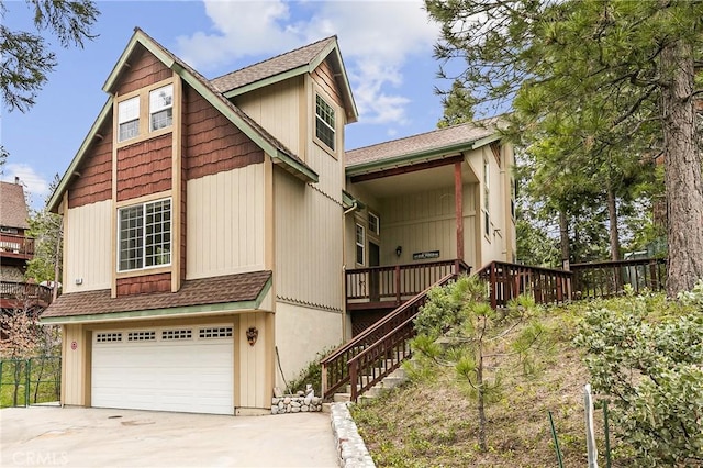 exterior space featuring an attached garage, a shingled roof, driveway, and stairs