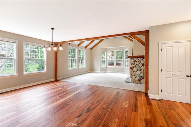 interior space with vaulted ceiling, a chandelier, light wood-style flooring, baseboards, and visible vents
