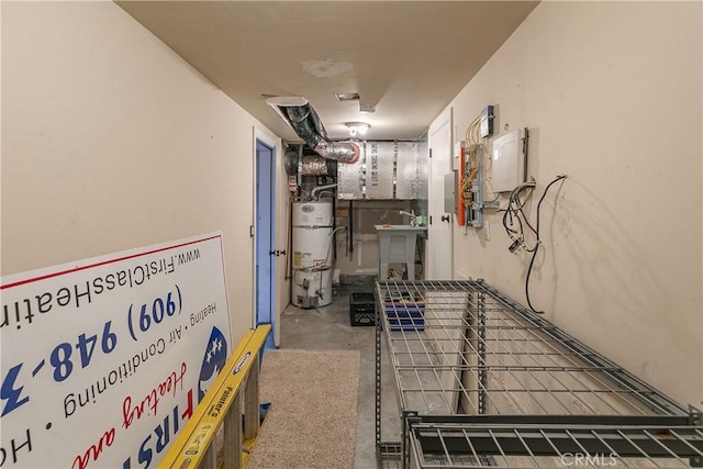 utility room with a sink, strapped water heater, and electric panel