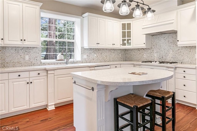 kitchen featuring a kitchen breakfast bar, light wood-style flooring, white cabinetry, and light countertops