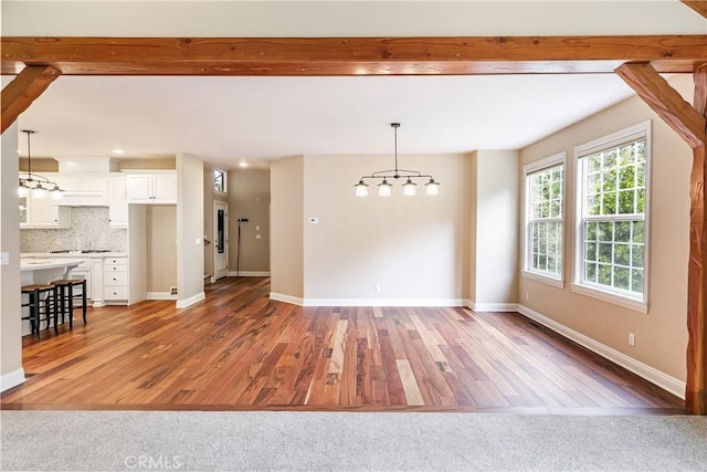interior space featuring a chandelier, light wood-style flooring, and baseboards