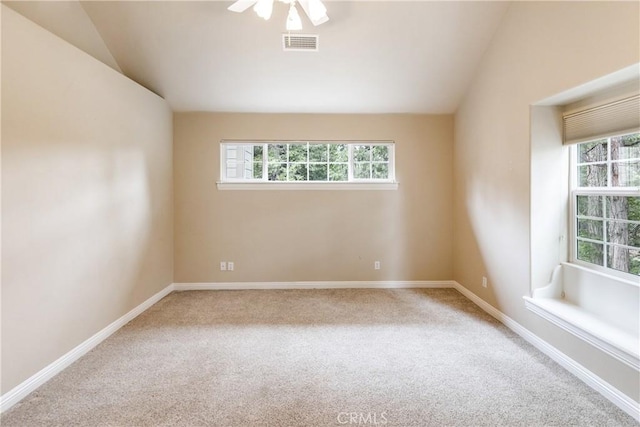 spare room featuring baseboards, lofted ceiling, visible vents, and carpet