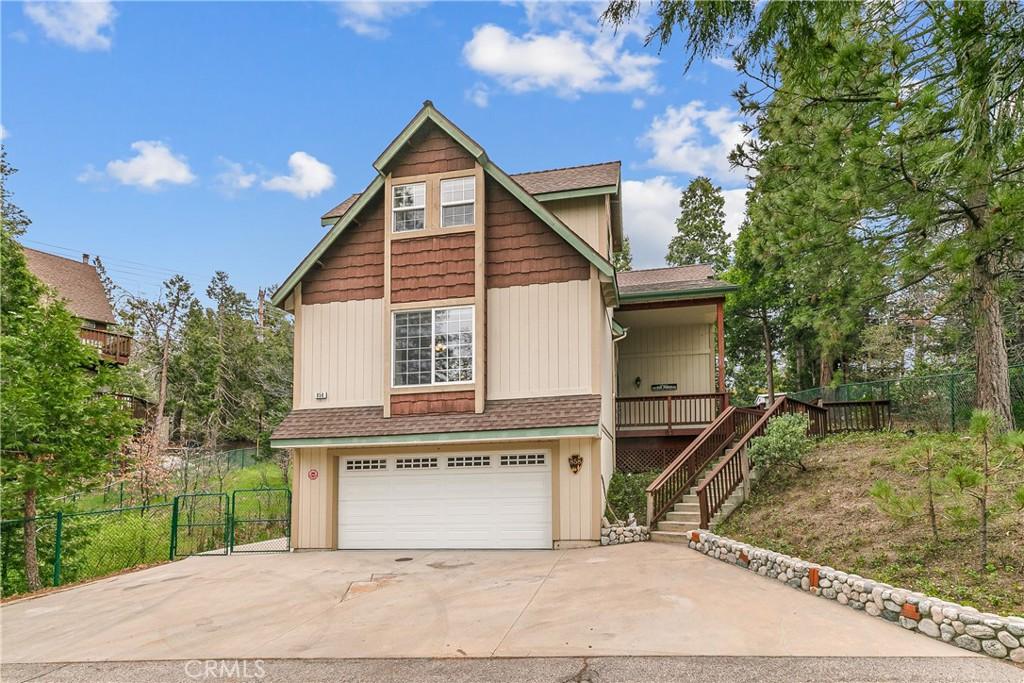 858 Grass Valley Rd, Lake Arrowhead, CA 92352 - view of front of house with stairway, roof with shingles, fence, an attached garage, and driveway