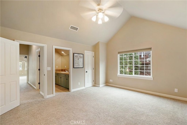 unfurnished bedroom featuring vaulted ceiling, visible vents, light carpet, a sink, and connected bathroom