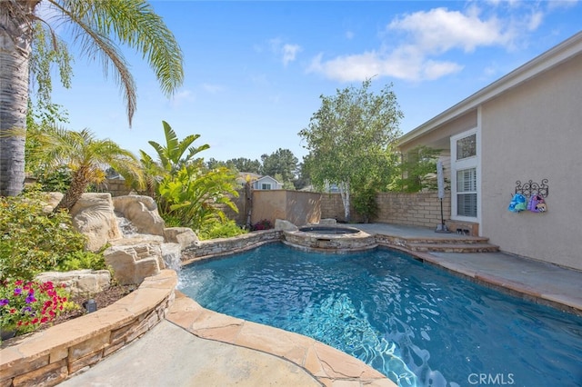 view of swimming pool featuring a fenced backyard, a pool with connected hot tub, and a patio