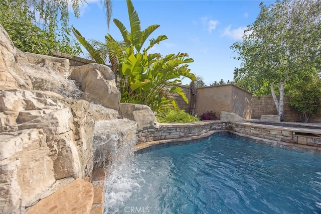 view of swimming pool featuring fence