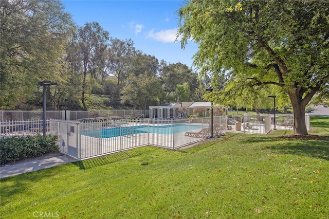 community pool with a yard, fence, and a patio