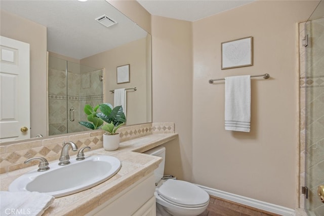 bathroom with vanity, toilet, a shower stall, visible vents, and decorative backsplash