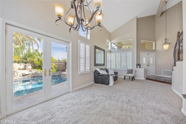 sitting room with visible vents, an inviting chandelier, french doors, high vaulted ceiling, and carpet flooring