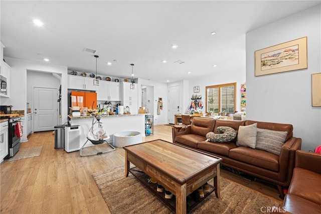 living area with light wood-style floors, recessed lighting, and visible vents