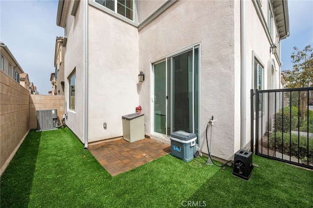back of house with central air condition unit, a fenced backyard, and stucco siding