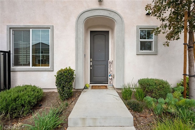 entrance to property featuring stucco siding