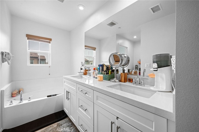 bathroom with a sink, double vanity, and visible vents