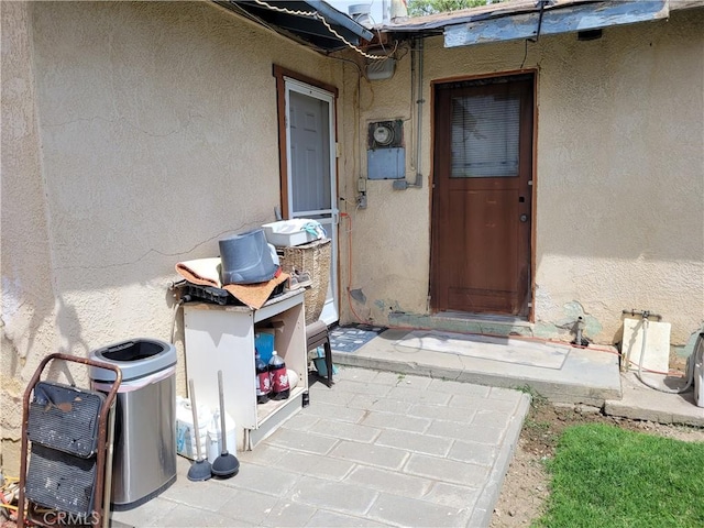 doorway to property featuring stucco siding