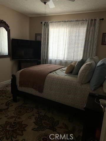 bedroom featuring a textured ceiling and ceiling fan