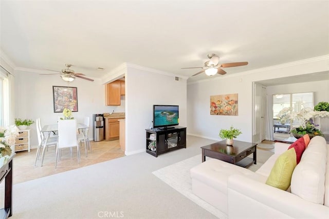 living room featuring light colored carpet, ornamental molding, a ceiling fan, and visible vents