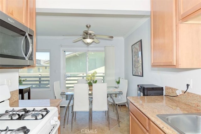 kitchen with stainless steel microwave, white range with gas cooktop, a ceiling fan, and ornamental molding