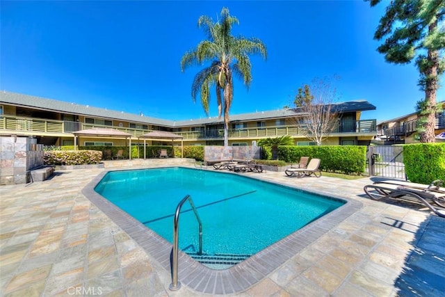 community pool featuring fence and a patio area