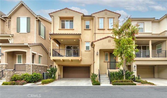 multi unit property with an attached garage, stucco siding, and driveway