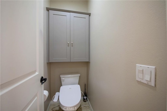 bathroom with baseboards and toilet