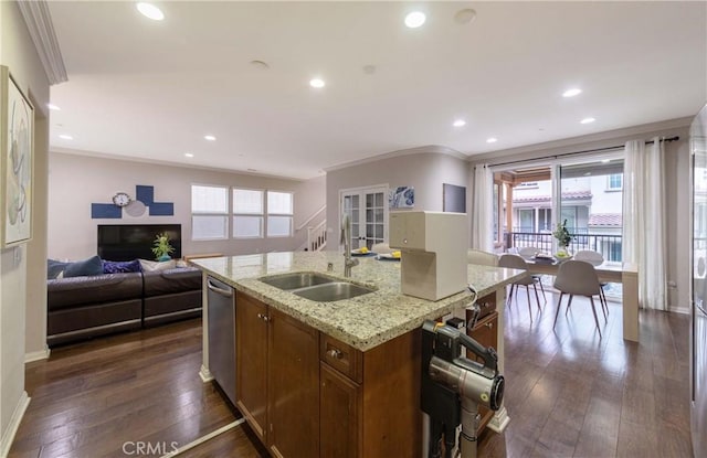 kitchen featuring brown cabinets, stainless steel dishwasher, a sink, crown molding, and open floor plan