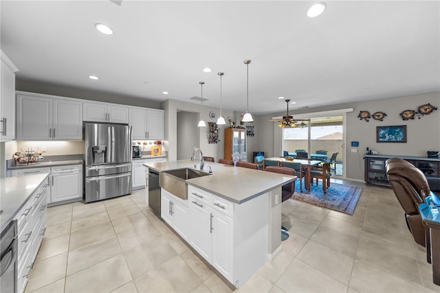 kitchen with a sink, open floor plan, recessed lighting, dishwashing machine, and stainless steel refrigerator with ice dispenser