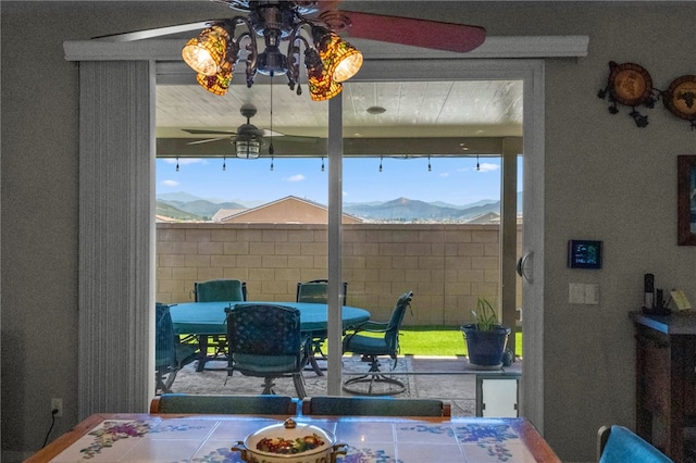 dining room featuring a ceiling fan and a mountain view
