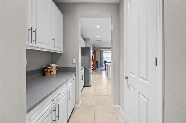 hallway featuring baseboards, recessed lighting, visible vents, and light tile patterned floors