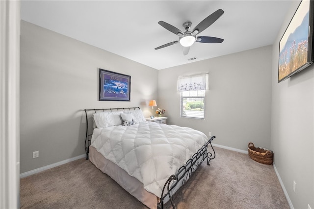 carpeted bedroom featuring baseboards, a ceiling fan, and visible vents