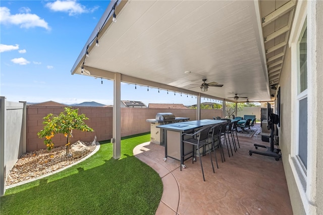 view of patio / terrace featuring a fenced backyard, outdoor dry bar, a grill, and ceiling fan