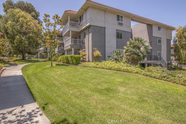 2399 Via Mariposa W Unit 2E, Laguna Woods, CA 92637 - view of home's exterior with stucco siding and a lawn